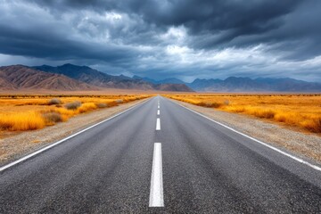 Fototapeta premium Desert road stretching into mountains under storm clouds