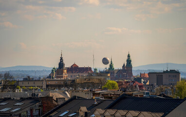 Historic Krakow skyline with iconic towers, rooftops, and distant hills under a clear sky. A perfect cityscape view of Poland's cultural heart.