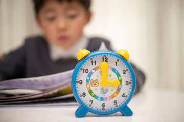 時計と勉強する子供
