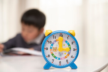 時計と勉強する子供