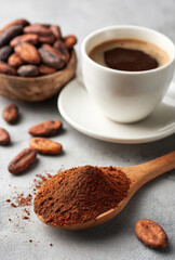 Cup of Black Coffee with Cocoa Powder and Cocoa Beans on Light Background