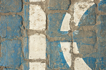 Old granite pavement painted in blue and white. Vertical and rounded line. Cobblestone, street, texture, paint, surface, rough. Design space. Top view.