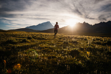 Runner running on the high altitude grassland mountain top