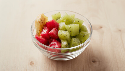 Diced dragon fruit and kiwi pieces artfully arranged in a minimalist glass bowl