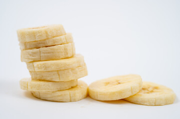 Stacked Sliced Bananas on White Background.