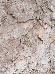 Weathered cracked plaster wall surface with beige tones. Ideal for backgrounds, architecture design, and restoration themes.
