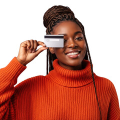 Smiling young woman wearing an orange turtleneck sweater holding a credit card over her eye isolated on transparent background
