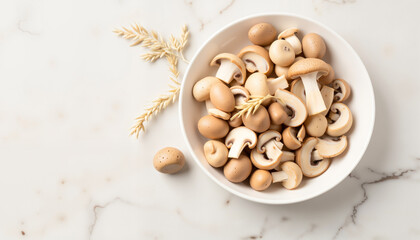 Fresh mushrooms in a round white bowl on marble surface  