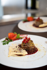 Gourmet Meat Medallion with Red Currants on White Plate