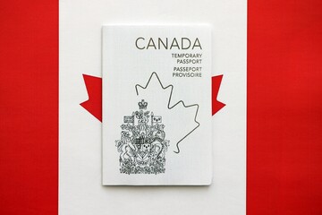 Canadian temporary passport lies on canadian flag close up
