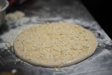 Raw Pizza Dough with Cheese Topping