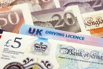 United Kingdom driving license card on UK British pounds money close up