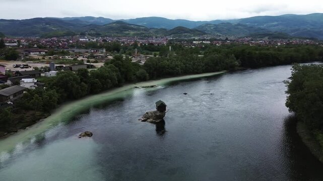 Famous Drina River house on a rock near Bajina Basta, Serbia, surrounded by water and forested mountains. Unique landmark and popular tourist attraction. Vertical aerial 4k footage
