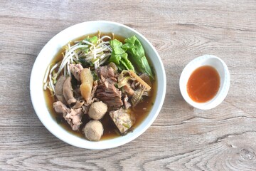 boiled braised beef meat and tendon couple organ in herb brown soup on plate dipping spicy chili sauce 