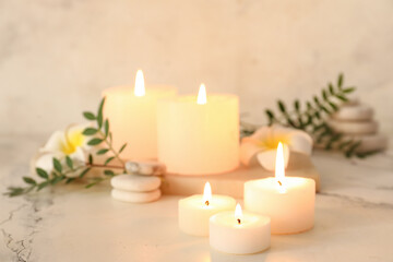 Spa composition with candles and flowers on light background, closeup