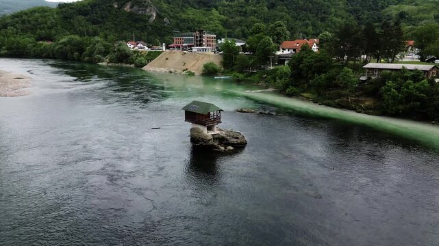 Famous Drina River house on a rock near Bajina Basta, Serbia, surrounded by water and forested mountains. Unique landmark and popular tourist attraction. Vertical aerial 4k footage
