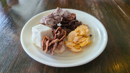 Assorted traditional dessert on white plate on wooden table