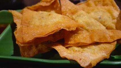 Close-up of crispy fried snack on green plate for appetizer or snack time