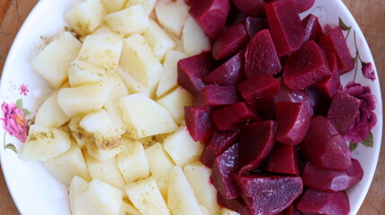 Moroccan beet and potato salad — diced boiled vegetables with cumin and olive oil, colorful plate, close-up top view