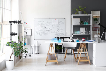Interior of modern medical laboratory with table and shelving units