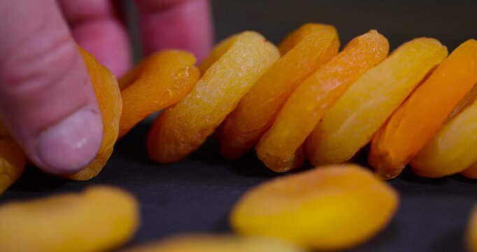 dried orange apricot fruits on a black slate board, dried seedless pure dried apricots for long-term storage and used as a sweet or for making compotes
