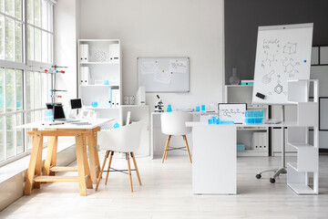 Interior of modern medical laboratory with tables and shelving unit