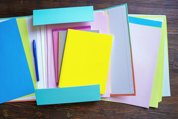  Open folder with workbooks and sheets of paper on dark rustic table, background. Copy space