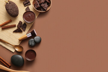 Spa composition with bowls of melted chocolate, spa stones and pumice stone on brown background