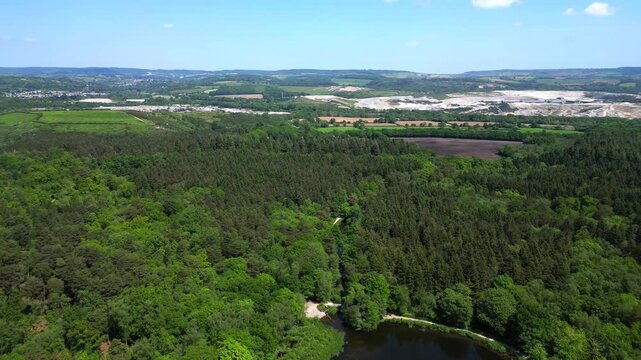 Newton Abbot, Devon, England: DRONE VIEWS: The drone flies over Stover Country Park revealing Stover lake; open cast clay mines are in the distance. The Bovey Tracey basin produces ball clay exports.