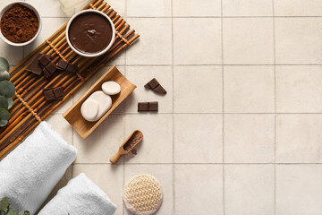 Beautiful spa composition with bamboo tray, bowls of melted chocolate and cocoa powder on tile background