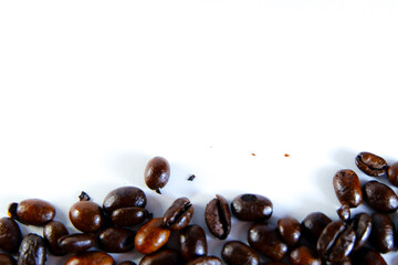 Rich roasted coffee beans spilling across a clean white surface, perfect for cafe menus, branding, or a vibrant morning start design element