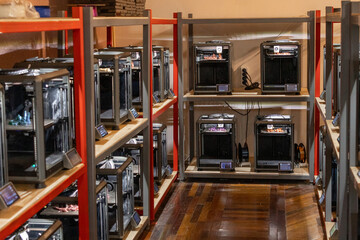 room with a large number of 3D printers, the creation of three-dimensional toys and parts in the...