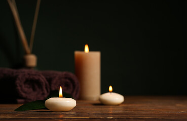 Beautiful spa composition with candles and towels on wooden background