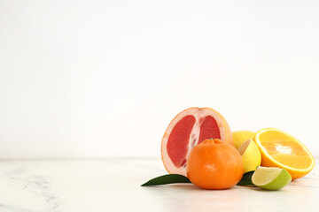 Different tasty citrus fruits on beige background