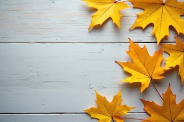 Autumn leaves on a white wooden background with copy space.