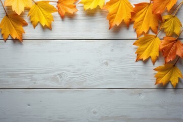 Autumn leaves on a white wooden background with copy space.
