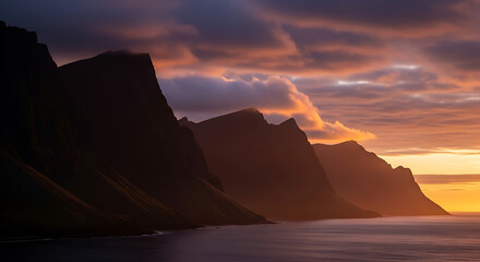 Naklejka premium Dramatic Sunset Silhouette of Coastal Cliffs Over the Ocean