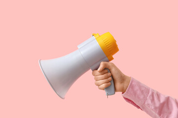 Female hand with megaphone on pink background, closeup