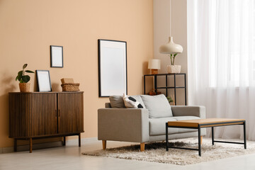 Interior of living room with sofa and chest of drawers near beige wall