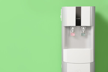 Modern water cooler near green wall, closeup