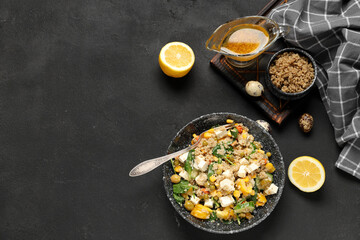 Bowl with healthy quinoa salad and ingredients on black grunge background