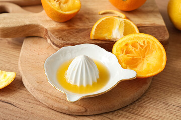 Ceramic juicer with orange juice on table in kitchen, closeup