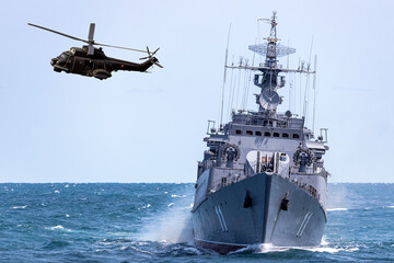 A helicopter flies near  warship during a naval exercise in the Black Sea.  © ValStock