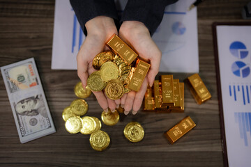 Adult hands hold valuable gold bars coins demonstrating wealth investment strategy on office desk...