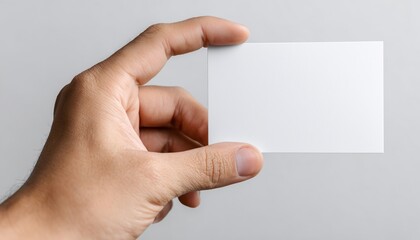 Fototapeta premium Man'S Hand Holding Blank Advertising Card Close Up Against White Background - Focus On The Details Of The Advertisement Card.