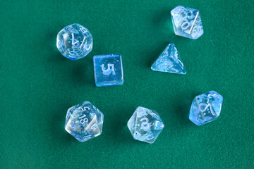 Blue game dices on green background, closeup