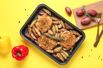 Baking tray with tasty baked vegetables on yellow background, closeup