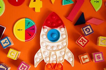  educational setup with colorful numbers, fraction pieces, and a rocket-shaped toy on a brown surface. Bright blocks and learning tools encourage math fun and creativity for kids, back to school