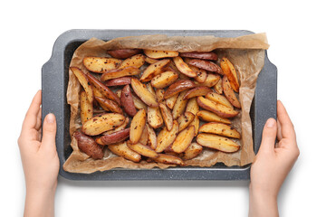 Young woman holding baking tray with tasty baked potato on white background, closeup