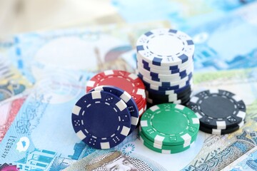 Bahraini dinar currency money bills and bunch of casino chips close up. The concept of gambling and casino games